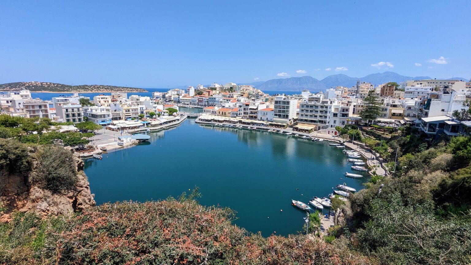 Lake Voulismeni in Agios Nikolaos, Crete, surrounded by white buildings and boats.
