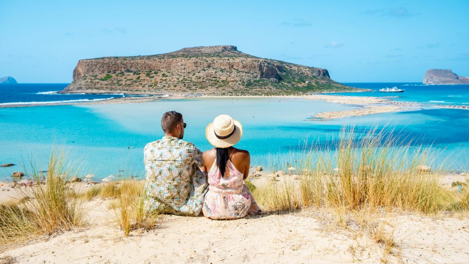 Couple siting by the balos beach in Crete Greece